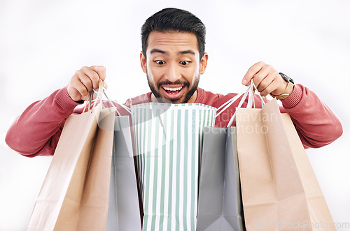 Image of Wow, sale and happy man with shopping bag in studio, excited for discount or purchase on white background. Deal, excited and indian guy with product form shop, mall or market while posing isolated