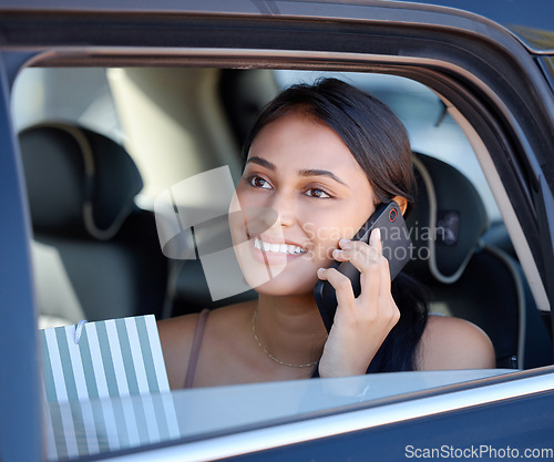 Image of Phone call, shopping and ride share with a woman customer sitting in the backseat of a car for transport. Travel, retail and communication with an attractive young female shopper in a vehicle