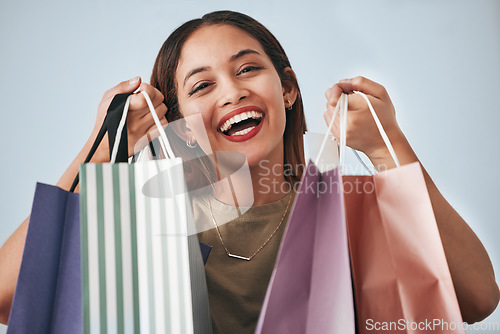 Image of Portrait, happy woman and shopping bag isolated on studio background wealth, financial freedom or sales promotion. Retail, fashion and beauty face of biracial person or customer with paper bags offer