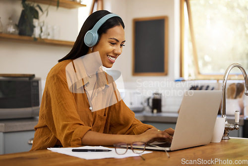 Image of Typing, remote work and woman on laptop happy at home working on project, strategy and planning in kitchen. Freelancer, business and girl with headphones for music, working online and streaming audio