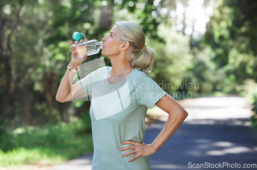 Image of Fitness, exercise and mature woman drinking water, outdoor and training for balance, fresh air and break. Senior female, nature and lady with aqua, retirement and thirsty after practice and workout