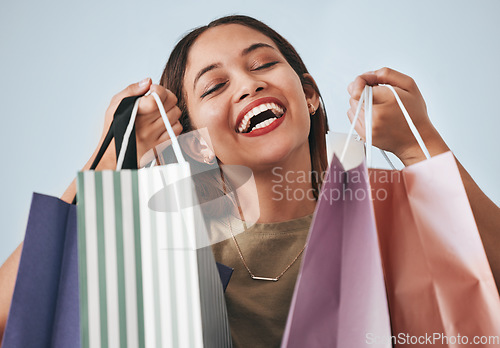 Image of Shopping bag, portrait and happy woman isolated on studio background wealth, financial freedom or sales promotion. Retail, fashion and excited face of model, person or customer with paper bags offer