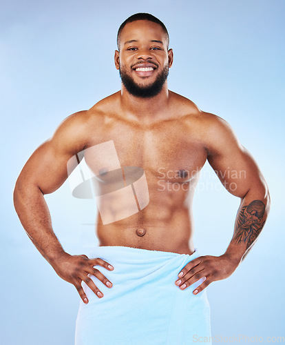Image of Man body muscle, towel and portrait of a male smile with happiness from bodybuilder exercise. Cleaning, skincare and wellness after workout and fitness with isolated, studio and blue background