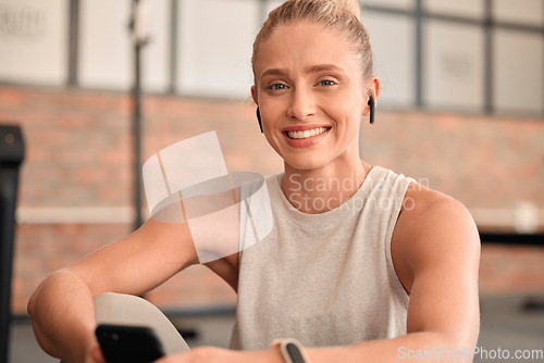 Image of Happy woman, portrait and earphones in gym with smartphone for radio, sports podcast and training. Female, fitness and listening to music with mobile app, happiness and social media in health club