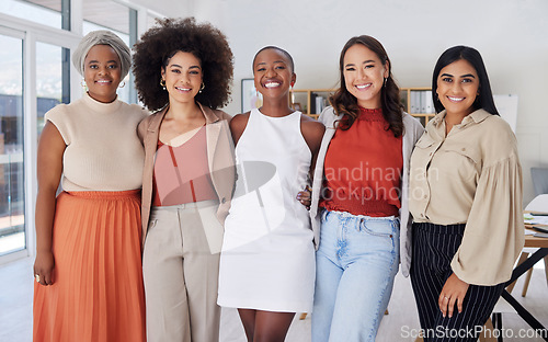 Image of Portrait of a diverse group of smiling ethnic business women standing together in the office. Ambitious happy confident professional team of colleagues embracing while feeling supported and empowered