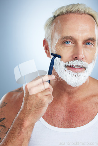 Image of Man, portrait and razor with shaving cream for grooming beard, skincare or hair removal against studio background. Mature male face with shaver, creme or foam product for hygiene or facial treatment