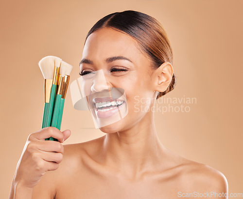 Image of Makeup brushes, portrait or happy woman laughing with facial products or self care on studio background. Face model, smile or funny girl smiling with beauty cosmetics or natural glowing skincare