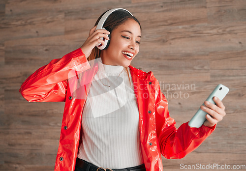 Image of Headphones, phone and happy woman with music isolated on wood background, audio streaming and mobile app. Gen z student or biracial person with cellphone, electronics sound or online audio technology