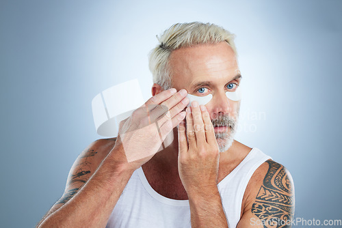 Image of Beauty, eye patches and senior man in studio for wellness, facial treatment and anti aging cosmetics. Skincare, dermatology and portrait of male model with face mask for detox, grooming and health