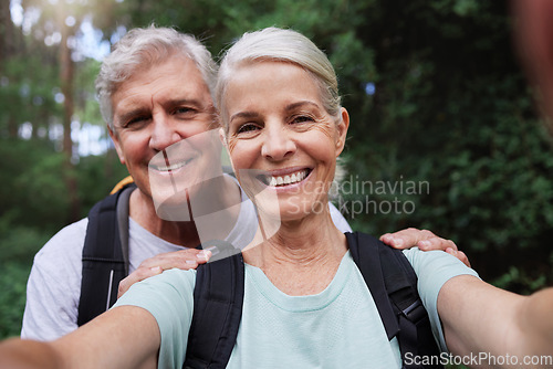 Image of Selfie, hiking and portrait of senior couple with smile on adventure in forest, woods and mountain for exercise. Fitness, retirement and happy elderly man and woman take picture trekking for wellness