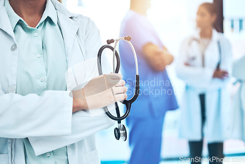 Image of Hands, stethoscope and doctor with arms crossed for cardiology in hospital or clinic. Healthcare, cardiologist or medical professional or confident woman with equipment for heart health or wellness.