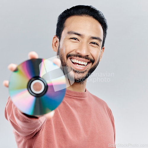 Image of Happy, showing and portrait of an Asian man with a cd isolated on a white background in a studio. Smile, excited and a Japanese person with a copy of multimedia, music or a movie on a backdrop