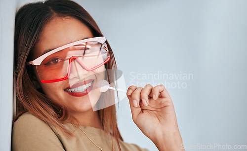 Image of Lollipop, woman and smile with makeup, cosmetics and gen z style eating a sweet candy. Lips, young person and studio background with mockup and a female model with sweets and cool fashion sunglasses