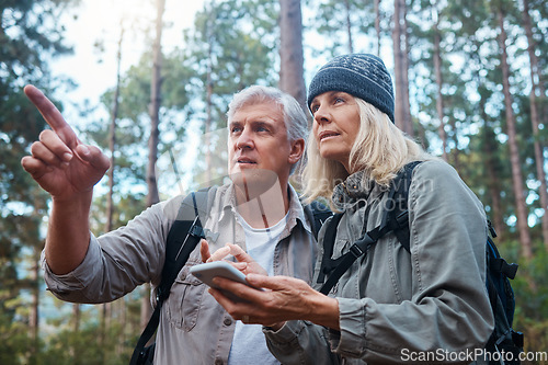 Image of Hiking, senior couple and phone outdoor in nature for direction for exercise, fitness and trekking. Old man and woman with smartphone pointing on forest hike for workout, cardio and gps or compass