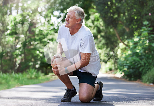 Image of Running, injury and old man with knee pain on path in nature for outdoor fitness and workout exercise. Health, wellness and muscle strain, senior runner with hand on leg in support or relief for ache