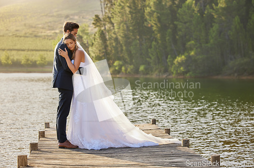 Image of Wedding couple, hug and love by lake in nature for relax or romantic honeymoon getaway. Calm woman hugging man in happy marriage relaxing by water together enjoying the loving embrace outdoors