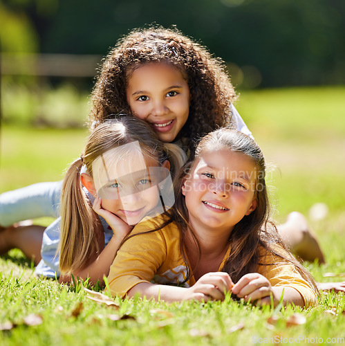 Image of .Summer, girls portrait or happy kids on grass in park together for fun, bonding or playing in nature. Smile, diversity or young best friends smiling or embrace on school holidays in outdoor field.