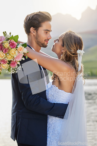 Image of Love, lake wedding and couple hug for bond commitment, romantic ceremony or union event in outdoor nature. Eye contact, flower bouquet and marriage of man, woman or fiance together in solidarity