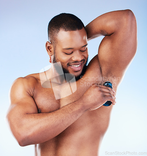 Image of Deodorant, skincare and black man for beauty, grooming and body hygiene on blue background. Wellness, health and male smile with antiperspirant, fragrance and scent product for underarm in studio