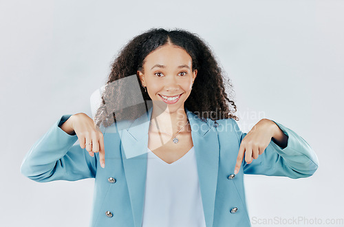 Image of Business woman, pointing down and studio portrait for mockup, promotion and space by white background. Happy entrepreneur, smile and hand sign for suggestion, mock up and happiness for company promo