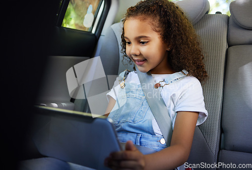 Image of Child in car, tablet and video on road trip with seatbelt for safety and device to play educational online game. Technology, internet browsing and travel, happy girl on backseat for drive or carpool.