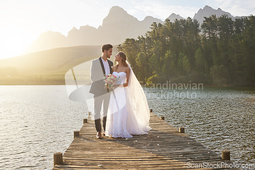 Image of Love, married or romance with a bride and groom on a pier over a forest lake in nature after their ceremony. Wedding, love and water with a young couple in celebration of their marriage outdoor