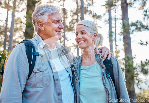 Image of Senior couple, hiking and happy outdoor in nature for exercise, fitness and trekking for health and wellness. Old man and woman smile and hug on hike in forest for workout, cardio and retirement