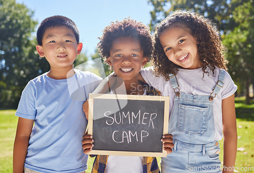 Image of Summer camp, portrait or children with board in park together for fun, bonding or playing in outdoors. Sign, diversity or happy young best friends smiling or embracing on school holidays outside