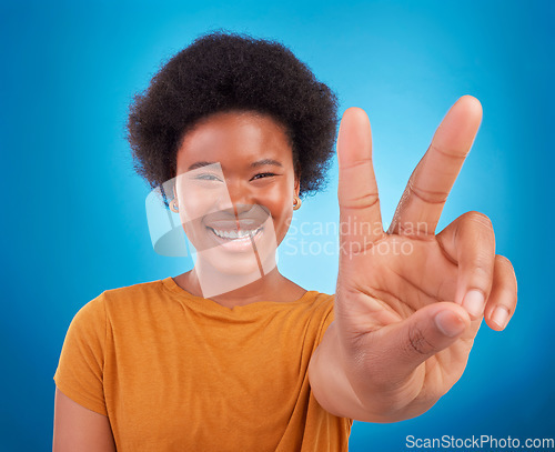 Image of Peace sign closeup, black woman hand and portrait of a model with a smile and happiness. Isolated, blue background and v hands gesture of a young female with a afro and beauty feeling excited