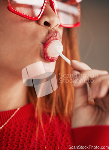 Image of Lollipop, woman and lips with makeup, cosmetics and gen z style eating a sweet candy. Mouth, young person and studio with brown background and a female model with sweets and fashion aesthetic