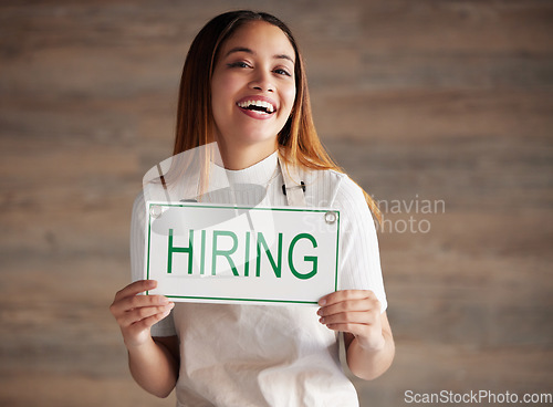 Image of Woman, portrait and hiring sign for small business recruitment, career or job opportunity against a studio background. Happy female entrepreneur with apron holding billboard poster for hire on mockup