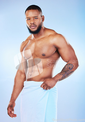 Image of Black man, portrait and body with a towel in studio for health, wellness and fitness. Face of serious male aesthetic model for clean body, strong muscle and skincare on a gradient blue background