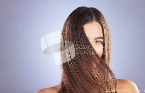 Image of Woman, beauty and hair portrait in studio for space, growth and healthy shine on blue background. Aesthetic female model for haircare texture, self care and cosmetic results for salon or hairdresser