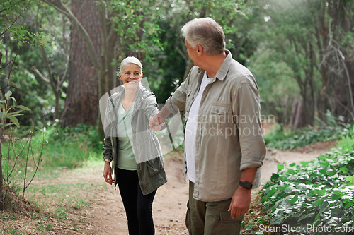 Image of Elderly couple, holding hands and hiking in a forest, happy and relax while walking in nature. Senior, backpacker and woman with man outdoors for travel, freedom and healthy lifestyle in retirement