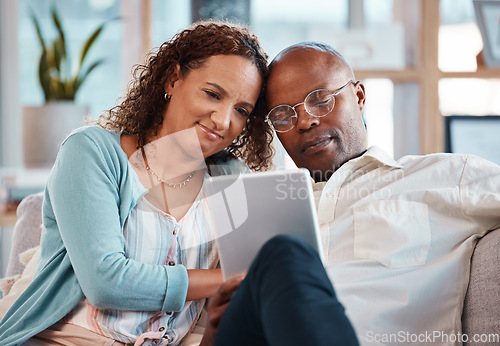 Image of Mature couple, tablet and sofa in home living room for bonding, love and video on app for memory. Black man, woman and mobile touchscreen to watch movie on internet in house on lounge couch to relax