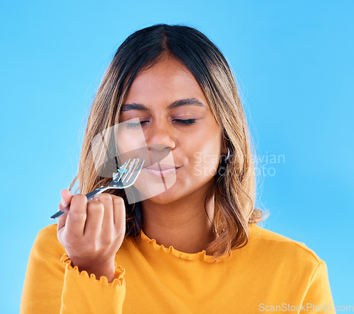 Image of Woman, fork and cake in studio for eating dessert, satisfied or eyes closed for happiness by blue background. Model, girl and happy for sweets, snack or test flavor for food, meal or diet by backdrop