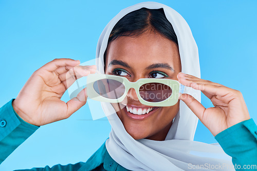 Image of Fashion sunglasses, face or happy Muslim woman with hijab, designer brand glasses or casual outfit style. Gen z summer aesthetic, Islamic model smile and Arabic Islam female on blue background studio