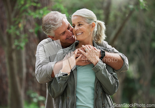 Image of Hug, hiking and senior couple in nature with smile on adventure in forest, woods and mountain for exercise. Fitness, retirement and happy elderly man and woman on trekking hike for travel wellness