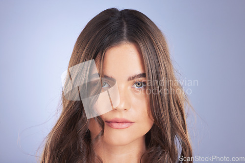 Image of Hair, woman and beauty face portrait in studio for skincare, growth and shine on blue background. Aesthetic female model serious with haircare, self care and cosmetic for salon or hairdresser results