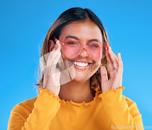 Image of Fashion, smiling or woman portrait with heart glasses, luxury designer brand style or casual summer outfit. Gen z aesthetic, trendy sunglasses accessory or female face model on blue background studio