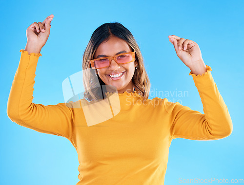 Image of Fashion portrait, dance and woman smiling with sunglasses, designer brand style or happy casual outfit. Gen z aesthetic, trendy glasses accessory or excited female celebrate on blue background studio