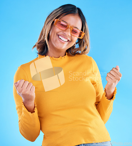 Image of Fashion celebration, excited or happy woman, studio winner and celebrate victory, luxury designer brand or casual outfit style. Success, winning achievement and gen z female cheers on blue background