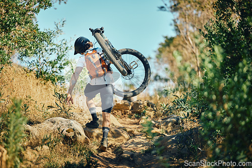 Image of Man, back and carrying bicycle in nature, walking and traveling outdoor in woods. Sports, fitness and male cyclist or athlete carry mountain bike for exercise, training or workout for transportation.