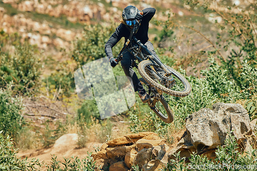 Image of Action, sports and mountain bike with man jumping in nature for cycling, fitness and adventure. Adrenaline junkie, performance and stunt with athlete riding outdoors for energy, risk and training