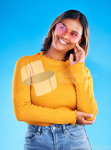 Image of Fashion, heart sunglasses and thinking happy woman with casual spring clothes, designer brand glasses or outfit style. Gen z aesthetic, trendy idea and young female model on blue background studio