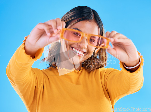 Image of Fashion sunglasses, happy portrait and woman face with clothes, designer brand or casual outfit style. Gen z summer aesthetic, trendy studio glasses and young female model on blue background