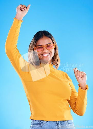 Image of Fashion celebration, portrait dance and happy woman, studio winner and celebrate victory, happiness or freedom. Winning achievement success, excited dancing and gen z female cheers on blue background