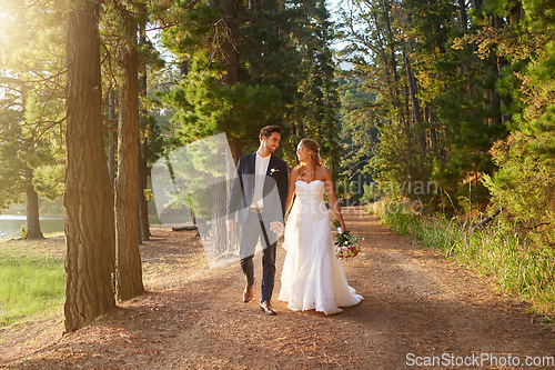 Image of Wedding, happy and couple walking in park, nature and forest for union celebration, care and marriage. Bride, groom and walk in woods, love and commitment to support, trust and smile together outdoor