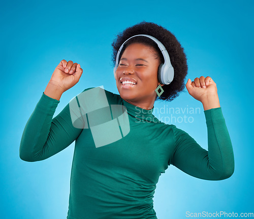 Image of Dance, music and headphones with black woman in studio for streaming, audio and relax. Online radio, technology and listening with female isolated on blue background for hip hop and movement