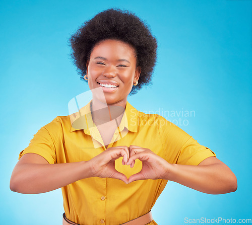 Image of Heart hands, happy black woman and portrait in studio, blue background and backdrop for hope. Female model smile for finger shape, love emoji and thank you of support, peace and care sign of kindness